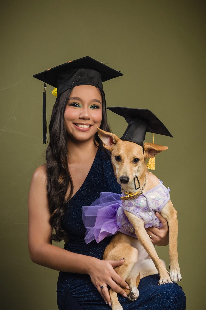 Graduada junto a su perro, ambos con birrete